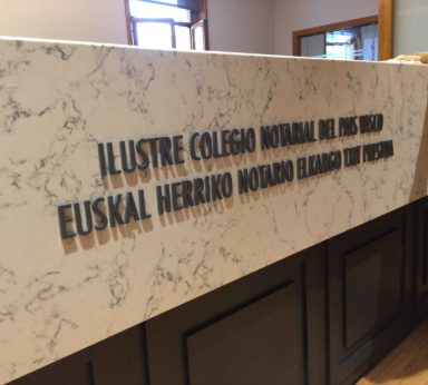 Letrero con letras metálicas sobre mármol del Ilustre Colegio Notarial del País Vasco en castellano y euskera